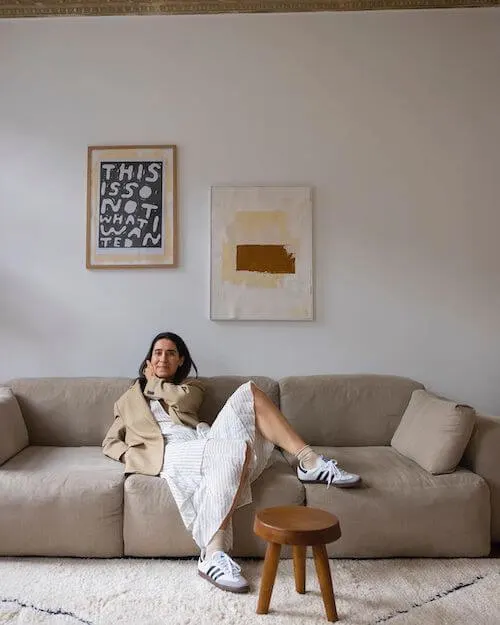 a woman wearing beige blazer, white maxi dress, and white Adidas Samba sneakers