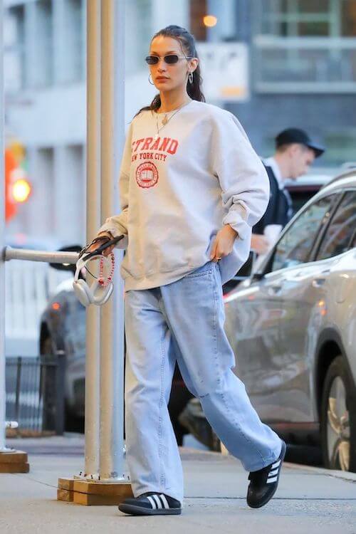 Bella Hadid wearing Adidas Samba sneakers, oversized sweatshirt, baggy jeans