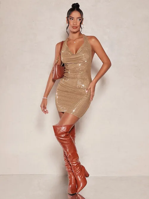 a sexy woman in a Vegas club wearing gold glittering dress and a pair of brown thigh high boots