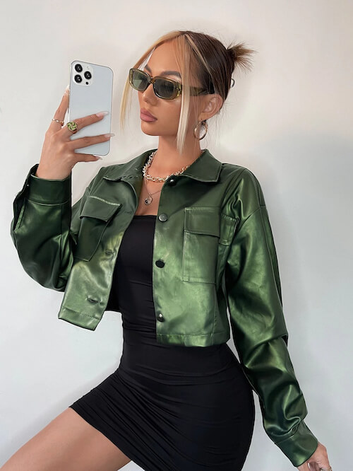 a woman wearing an edgy jacket, a black bodycon mini dress, sunglasses, and stylish necklaces