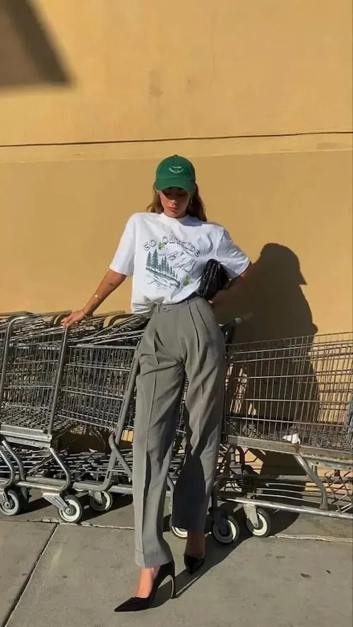 a woman wearing a baseball cap, Tee, and wide leg pants