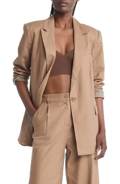 black woman wearing a beige blazer and beige pants