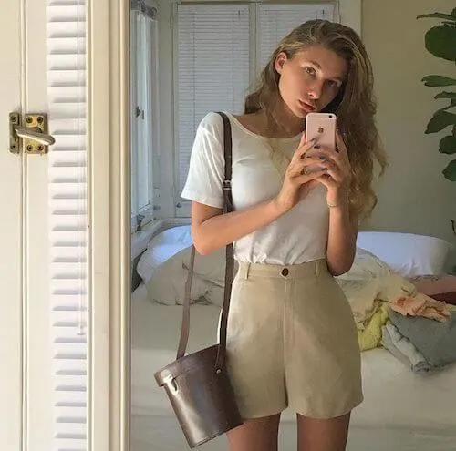 a woman wearing a white tee and beige shorts