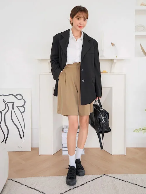 a Korean woman wearing beige shorts, black blazer and white shirt