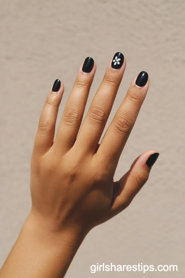 Minimal Black Nails with White Floral Accent on Short Rounds