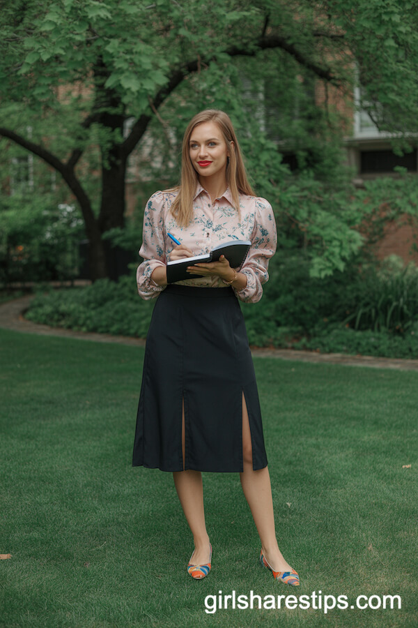 Floral blouse tucked into high-waisted black skirt
