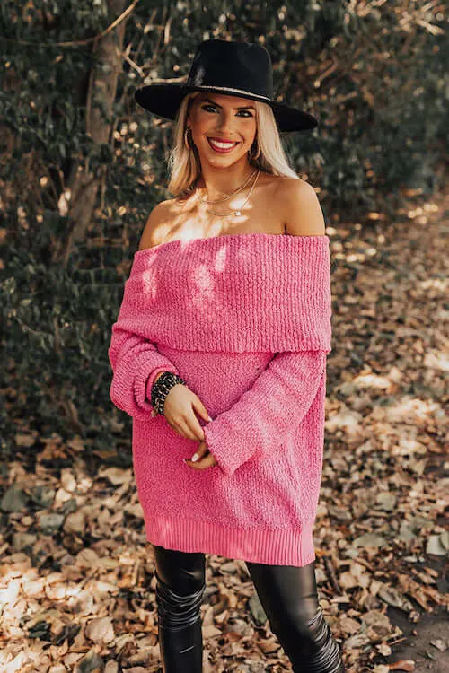 a woman wearing a pink off the shoulder sweater, black leather leggings, and a black hat