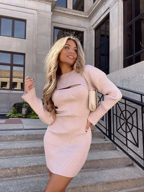 a woman wearing a cut out blush pink sweater dress