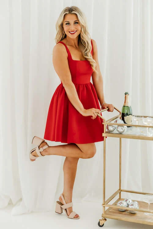 a woman at home wearing a cute red skater dress