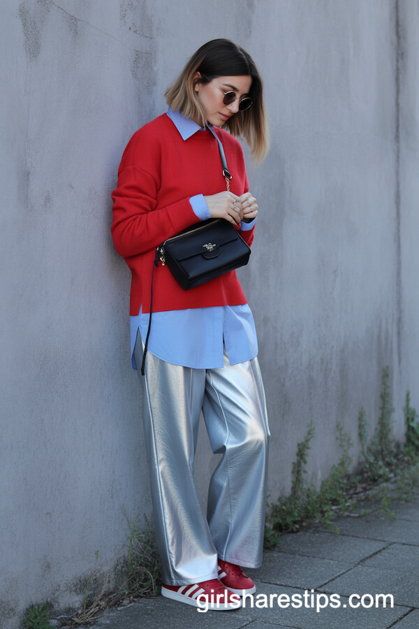 Red Sweater Layered Over Blue Shirt With Silver Trousers And Red Sneakers