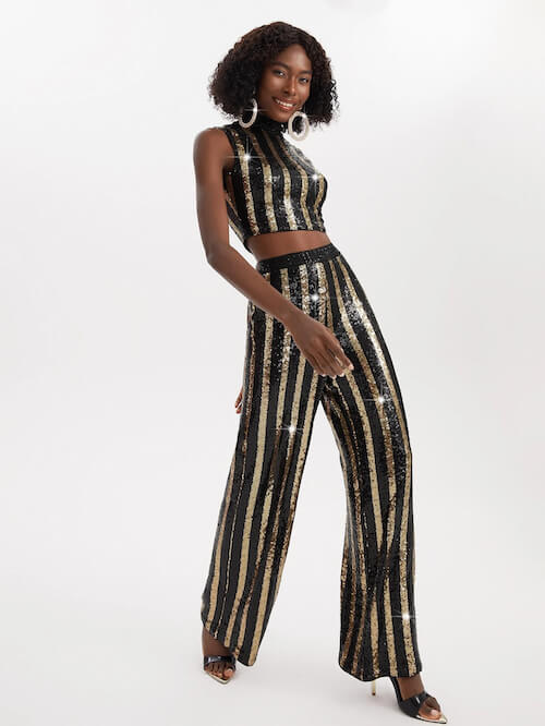 a black woman wearing gold and black outfit for a party