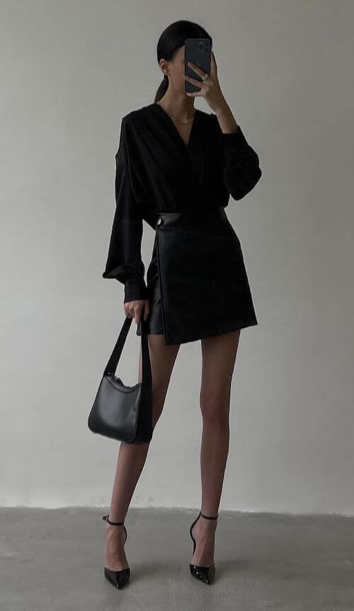 a woman waring a short dress, black tights and a black purse