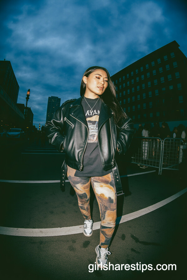 Leather jacket and graphic tee with printed pants and sleek sneakers