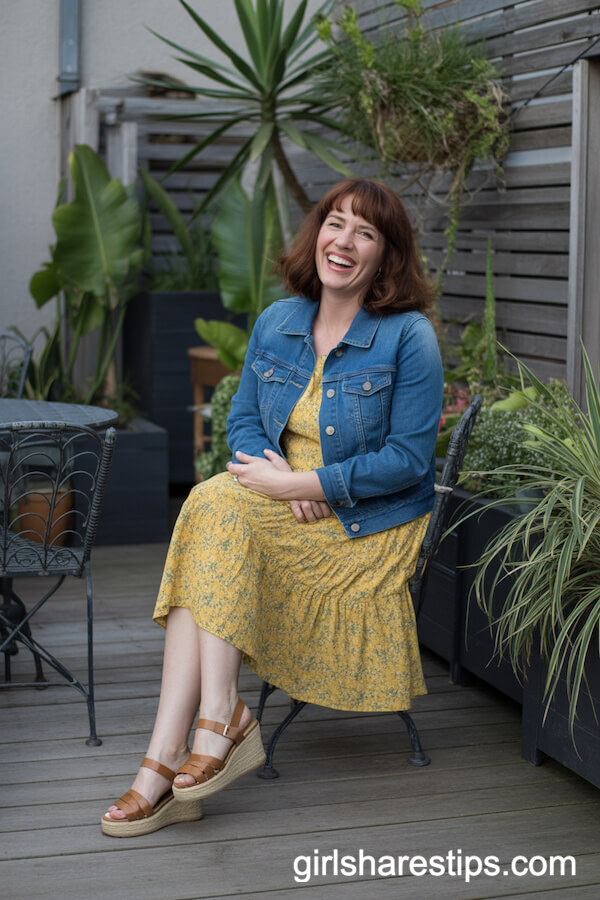 Blue denim jacket layered over a yellow floral tea dress