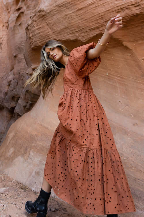 woman wearing a brown maxi dress and a pair of black leather boots