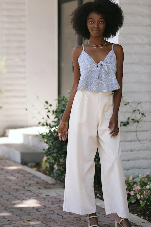 a black woman wearing a cute cami top and a pair of white linen pants