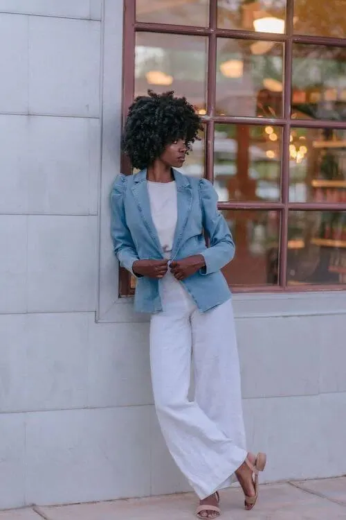 a black woman wearing a denim jacket and white linen pants