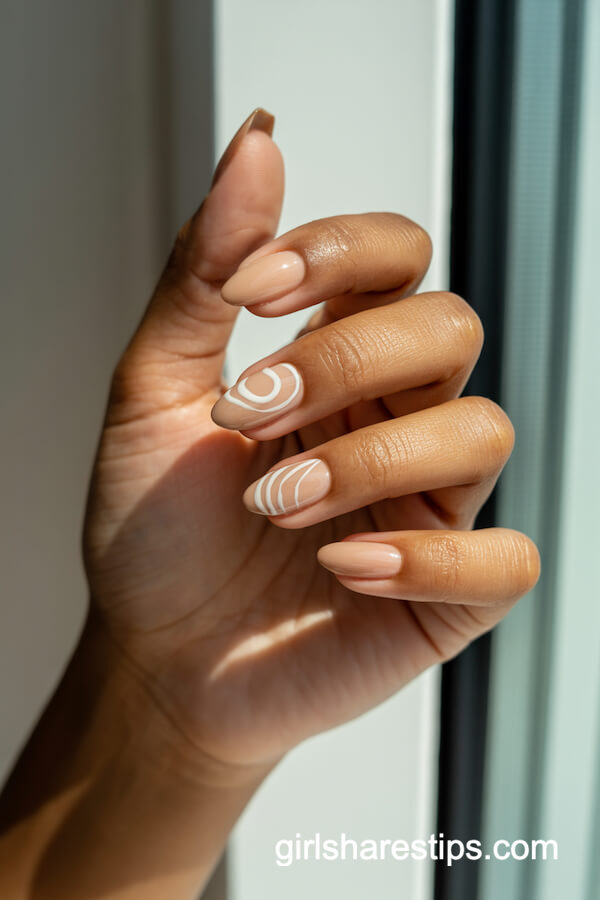 Almond beige nails with white swirls