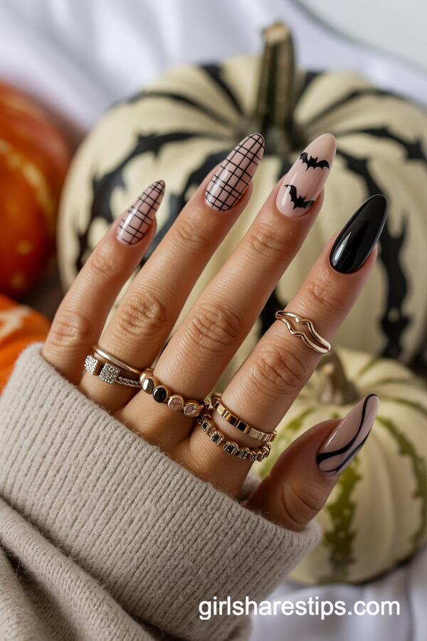 Nude nails with black checkered pattern, bats, and abstract details