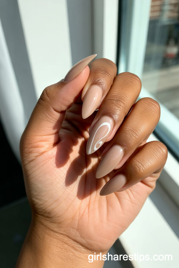 Sandy Beige Stiletto Nails with Minimalist White Swirl Art