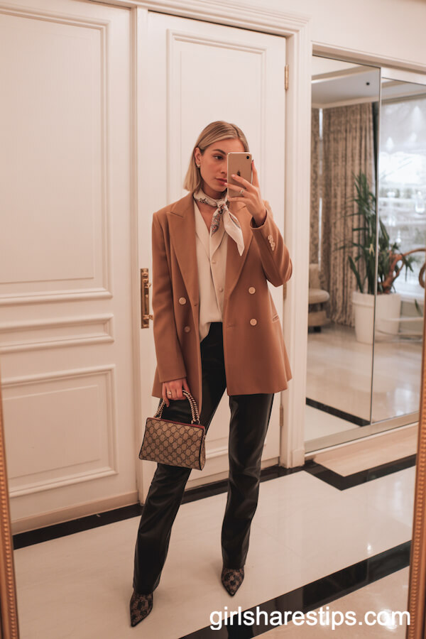 Camel Coat and Cream Blouse Over Black Slim Pants