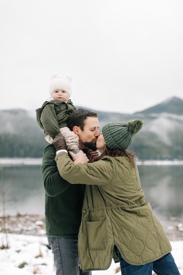 Dad and Mom Kissing with Baby in Winter