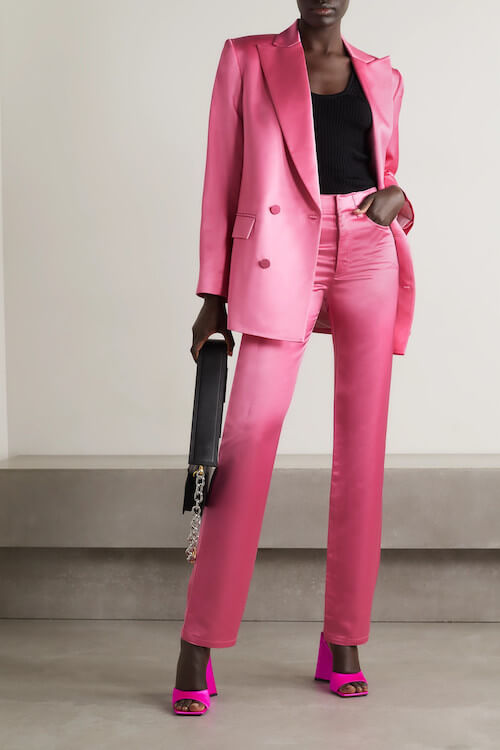 a black woman wearing pink blazer suit, pink shoes, and black tank top