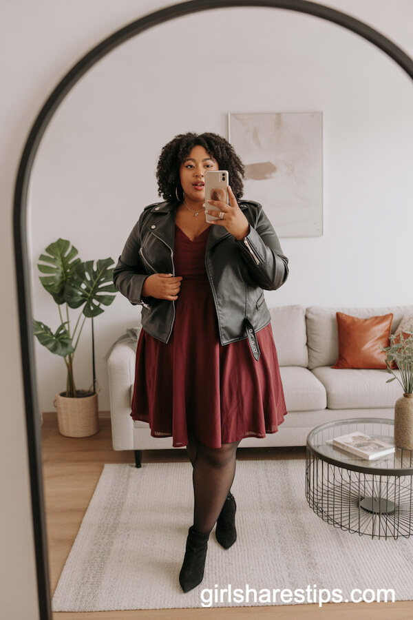Black leather moto jacket over burgundy A-line dress