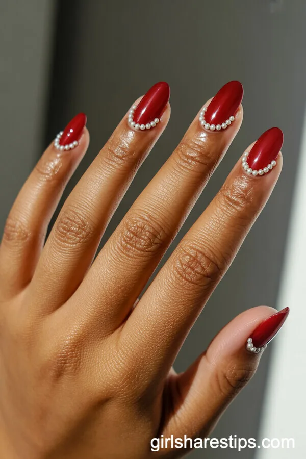 Elegant Red Almond Nails with Pearl Cuticle Lines