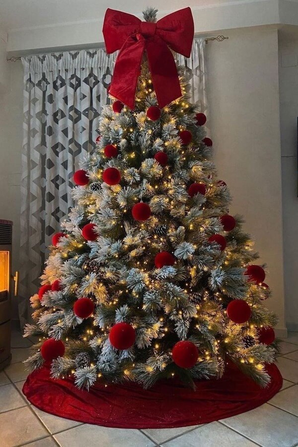 Snow Flocked Tree with Red Ball Ornaments and Big Red Bow