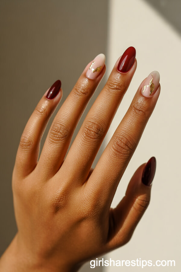 Dark Cherry Red Oval Nails With Gold Leaf Accents