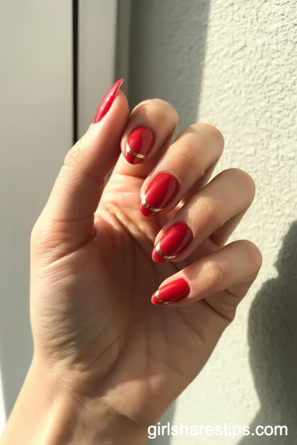 Red Almond Nails With Thin Gold Tip Striping