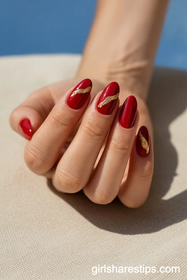 Cherry Red Almond Nails with Gold Foil Accents