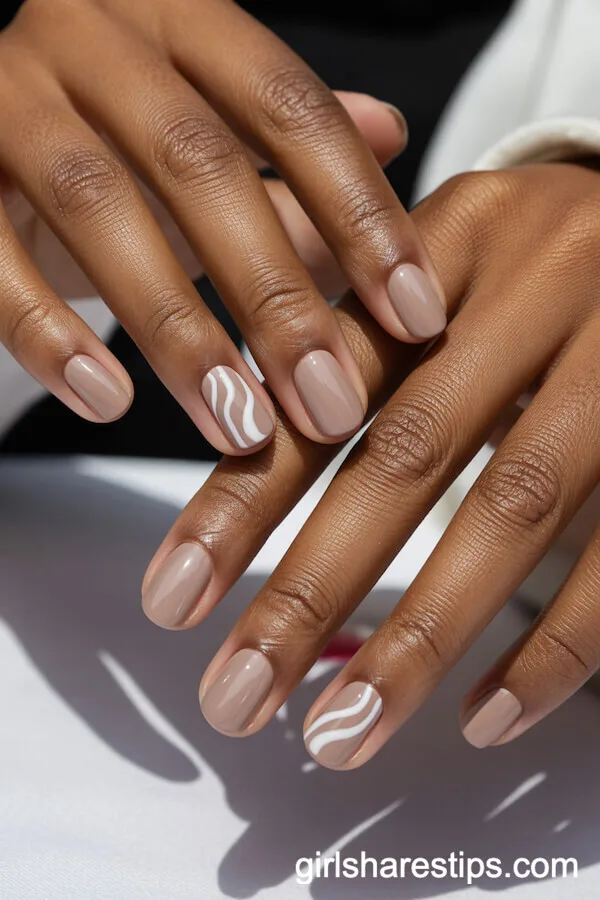 Neutral Beige Nails with White Swirl Accent