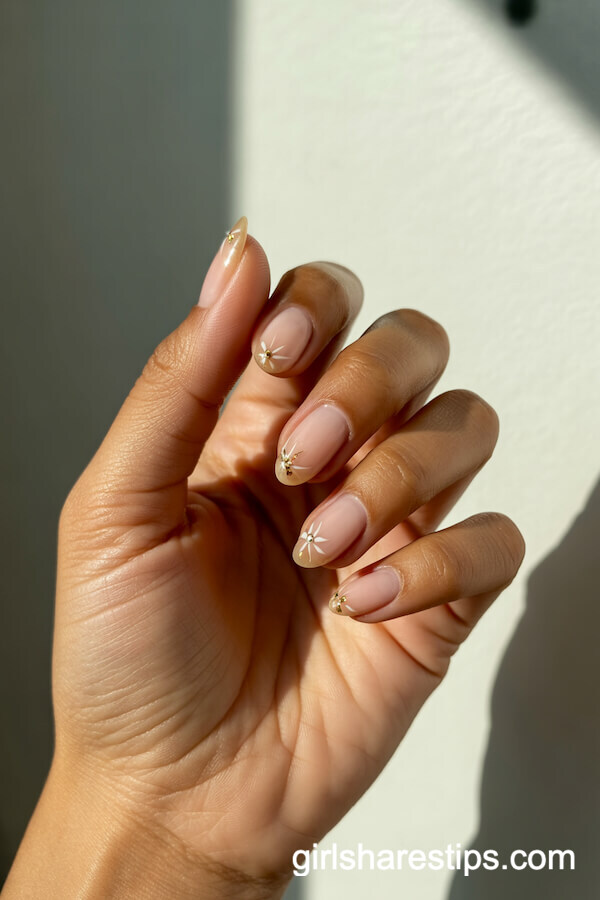 Nude Almond Nails with White and Gold Starbursts