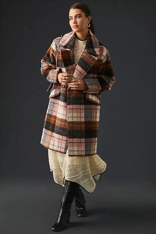 a woman wearing a flowy maxi dress and a plaid mid-length coat