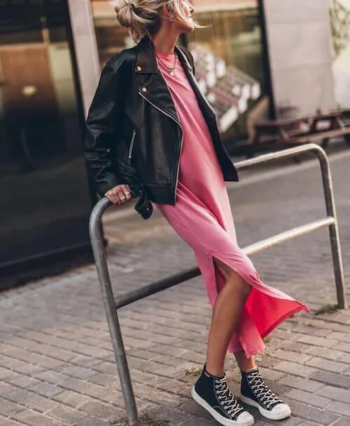 a woman wearing a pink long dress and a black leather jacket