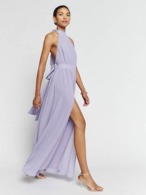 a woman wearing a light purple dress with a pair of nude strappy sandals to a wedding