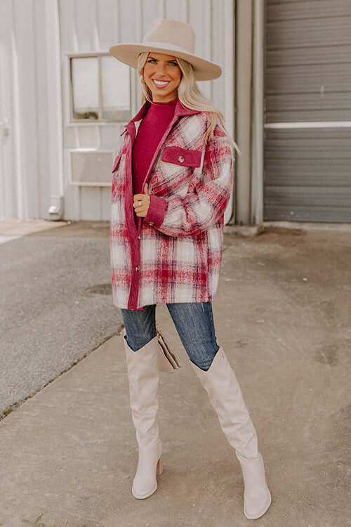 a woman wearing plaid long shacket, skinny jeans, white cowgirl boots, and a cowgirl hat