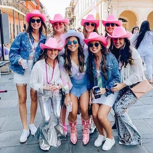 a group of women in a Nashville bachelorette weekend wearing fun cowgirl inspired outfits