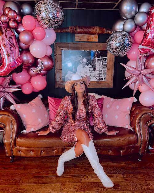 a woman wearing cowgirl costume in a pink party