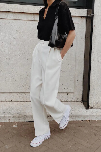 Free Photo  Full length photo of stylish woman dressed in black trousers  and white shirt and standing on the street against the modern building  style and fashion concept